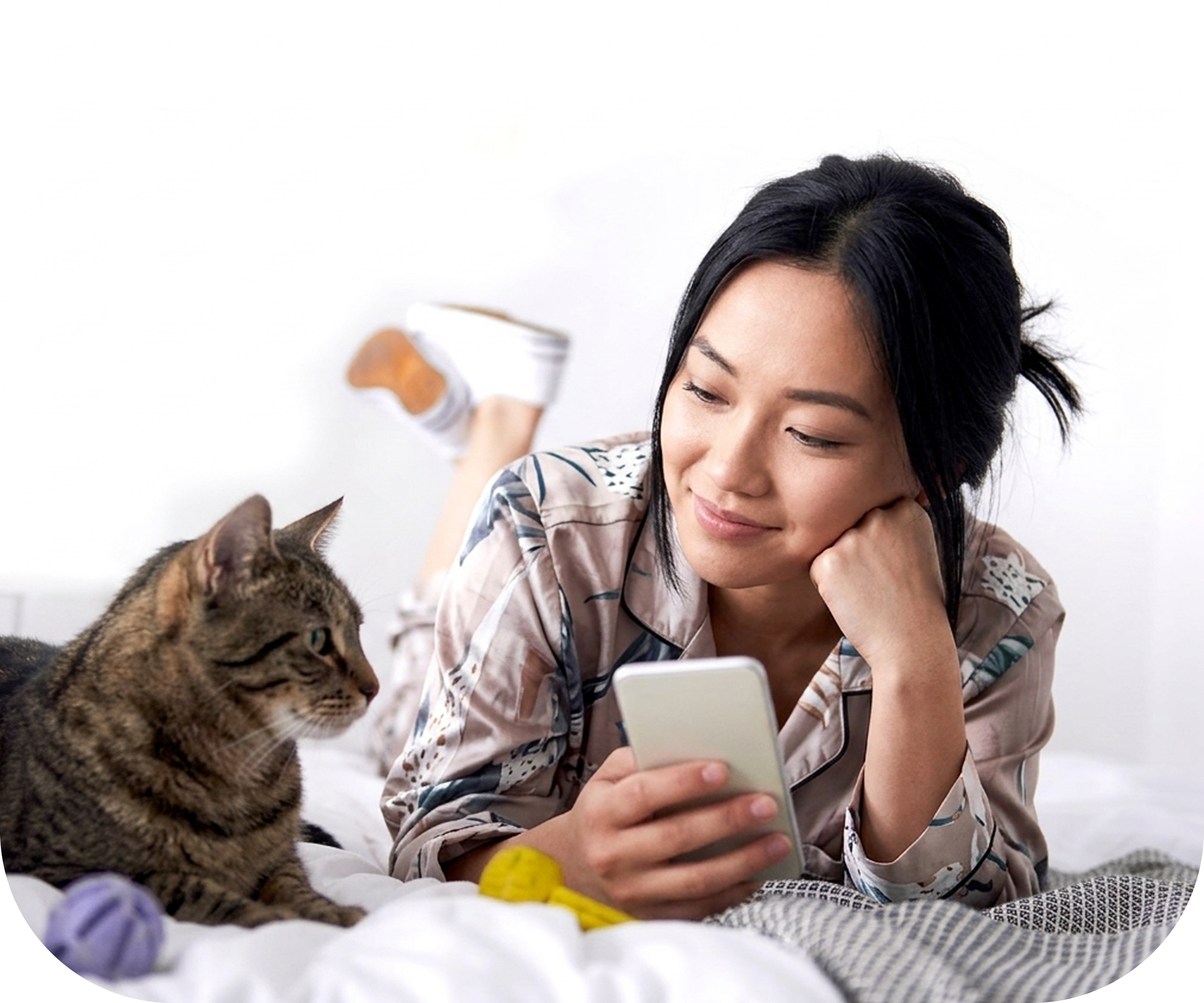 Woman relaxing with her cat while using a phone
